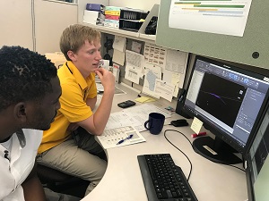 Two interns working together at a desk.