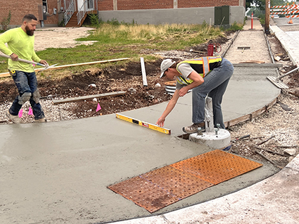 Construction workers working on a curb ramp.