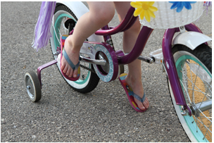 Bicycle rider with inappropriate footwear.